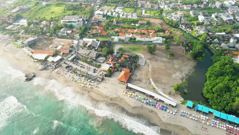 Beach-resort-and-housing-in-Canggu-beach,-aerial-drone-orbit-view