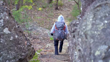Indigenes-Australisches-Mädchen,-Das-Durch-Zwei-Große-Felsbrocken-Im-Blue-Mountains-Nationalpark-Hinabsteigt