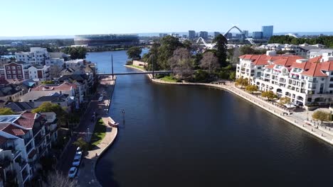 Vista-Aérea-De-Drones-Viajando-Hacia-Atrás-Sobre-El-Puente-Peatonal-Colgante-En-Claisebrook-Cove,-Perth-Oriental-Con-Estadio-Optus-Y-Río-Swan