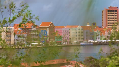 Langsamer-Filmischer-B-Roll-Schiebeschwenk-Von-Links-Nach-Rechts-über-Die-Stadt-Willemstad-Mit-Den-Ikonischen,-Farbenfrohen,-Zum-Weltkulturerbe-Gehörenden-UNESCO-Gebäuden-Der-Handelskade-In-Punda,-Curaçao