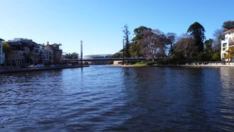 Drohne-Schwebt-über-Dem-Wasser-In-Claisebrook-Cove,-East-Perth,-Mit-Hängebrücke-In-Perth,-Westaustralien
