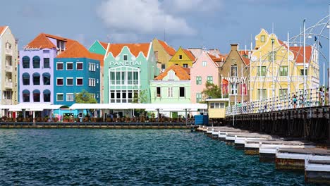 4K-24fps-Panorama-Der-Eröffnung-Der-Queen-Emma-Brücke-In-Willemstad-Mit-Den-Ikonischen,-Farbenfrohen-UNESCO-Welterbegebäuden-Der-Handelskade-In-Punda,-Curaçao