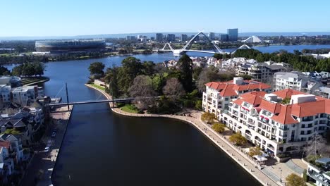 Drone-Aerial-View-descending-down-over-water-of-Claisebrook-Cove,-East-Perth-and-Optus-Stadium,-Swan-River-and-Matagarup-Bridge,-Western-Australia