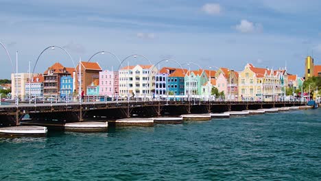 4k-60fps-Filmischer,-Breiter-Parallaxenflug-Der-Schwimmenden-Königin-Emma-Brücke-Mit-Touristen-Und-Fußgängern,-Die-Darüber-Laufen,-In-Der-Stadt-Willemstad,-Curaçao