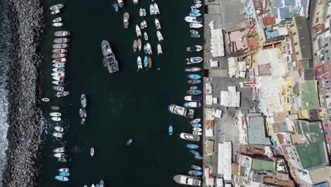 Vista-Aérea-De-Arriba-Hacia-Abajo-De-Los-Barcos-De-Pesca-Anclados-En-El-Mar-Mediterráneo-En-Los-Suburbios-De-Nápoles,-Italia,-Disparo-De-Drones-De-Gran-ángulo