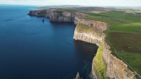Drone-shot-of-the-Cliffs-of-Moher-and-the-Irish-farmland-at-sunset
