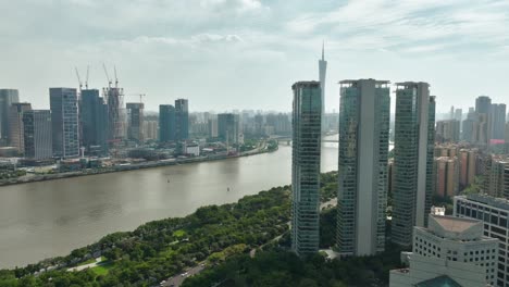 Vista-Aérea-Alrededor-De-Los-Edificios-De-Apartamentos-En-El-Río-Perla,-Revelando-La-Torre-Del-Cantón-En-Guangzhou,-China