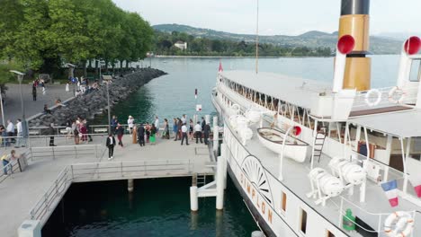 People-deboarding-a-beautiful-classic-cruise-ship-on-lake-Geneva,-Switzerland
