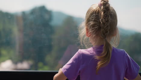 Curious-little-girl-enjoys-fantastic-highland-from-ropeway