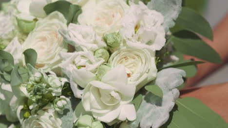 Woman-bride-holds-gorgeous-wedding-bouquet-of-white-roses