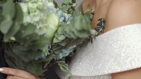 Man-gives-fresh-bouquet-to-beloved-woman-in-sparkling-dress