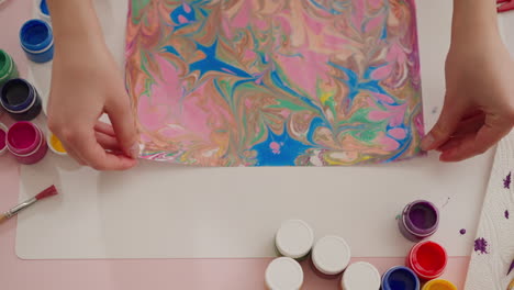 Young-woman-puts-wonderful-picture-with-marbling-patterns