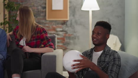 Smiling-African-American-guy-plays-with-ball-watching-match