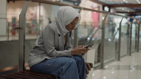 Muslimische-Schwarze-Frau-Chattet-Am-Telefon-In-Der-Halle-Des-Einkaufszentrums