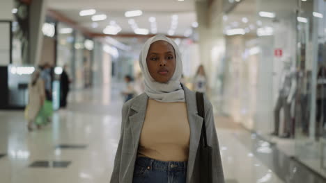 Confident-African-American-woman-in-hijab-walks-along-mall