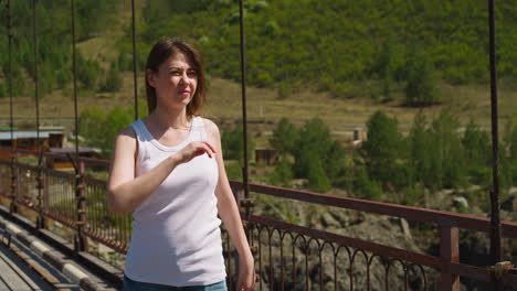 Woman-with-half-shut-eyes-walks-on-bridge-against-mountain