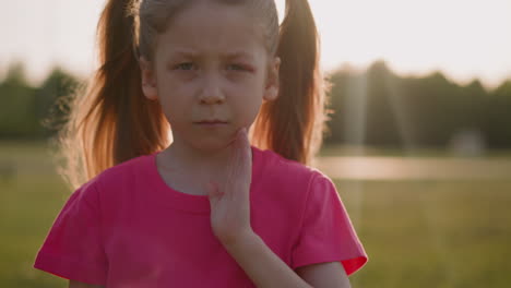 Crying-little-girl-holds-bruise-on-eye-standing-on-field