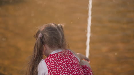 Little-blonde-girl-plays-with-fountain-water-in-urban-park