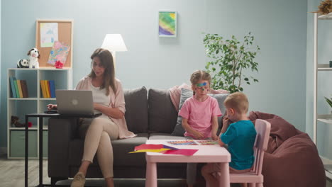 Woman-works-on-laptop-neglecting-playful-children-in-room