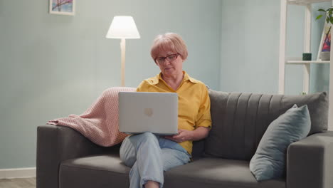 Tranquil-mature-woman-works-on-laptop-sitting-at-home