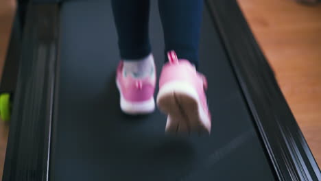 active-girl-in-pink-sneakers-runs-on-athlete-track-at-home