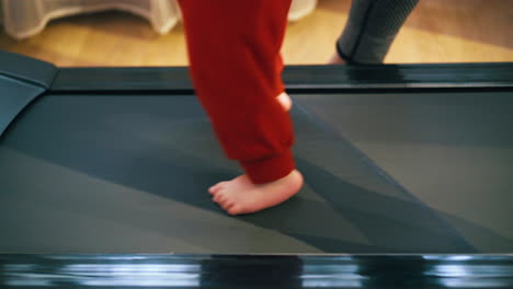 Un-Niño-Descalzo-Con-Pantalones-Sueltos-Camina-Por-La-Pista-De-Atletismo