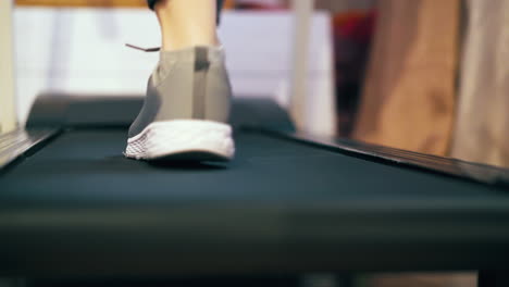 woman-in-grey-sneakers-walks-on-treadmill-low-angle-shot