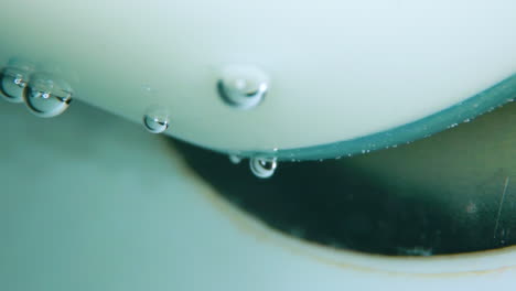 Luftblasen-Auf-Weißem-Kunststoff-Und-Fließendes,-Klares-Wasser
