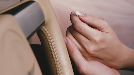 man-strokes-girlfriend-hand-near-steering-wheel-in-car-salon