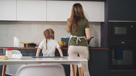 mom-and-little-daughter-in-kitchen-stand