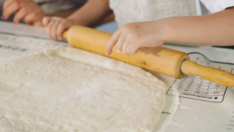 little-girl-in-kitchen-prepares-dough,-rolling