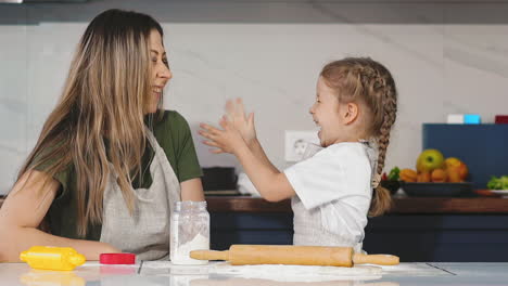 little-girl-in-kitchen-with-her-mother-having-fun