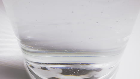 Blasen-Steigen-In-Sprudelndem-Wasser-Mit-Eiswürfeln-Im-Glas-Auf