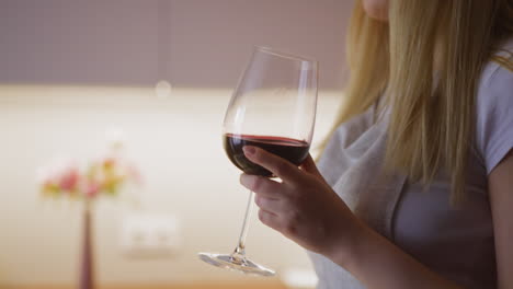 Frau-Trinkt-Rotwein-Zum-Sammeln-Und-Tanzt,-Während-Sie-Essen-Zubereitet