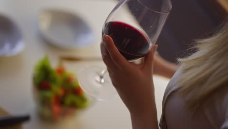 Frau-Macht-Salat-Am-Tisch,-Konzentriert-Sich-Auf-Die-Hand-Mit-Weinglas