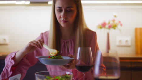 Frau-Mit-Rotwein-Nimmt-Salat-Beim-Romantischen-Abendessen