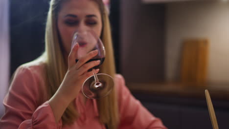 Woman-enjoys-wine-and-smiles-to-partner-at-conversation