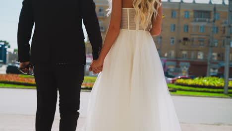 Just-married-woman-and-man-join-hands-standing-on-street