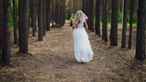 Pretty-woman-in-wedding-dress-and-sneakers-runs-along-forest