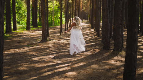 Bride-with-loose-hair-in-sneakers-runs-through-pine-forest