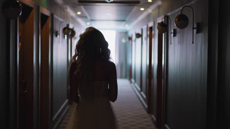Silhouette-of-curly-haired-lady-in-wedding-dress-in-corridor