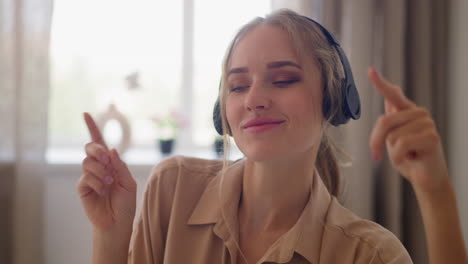 Woman-in-headphones-enjoys-music-in-home-office-room