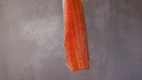 Expensive-cool-smoked-salmon-fillet-hangs-turning-in-smoke
