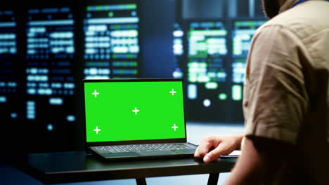 Programmer-using-green-screen-laptop