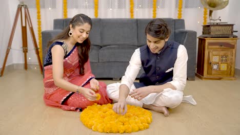 Indian-couple-making-flower-Rangoli