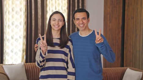 Cute-Indian-couple-showing-victory-gesture
