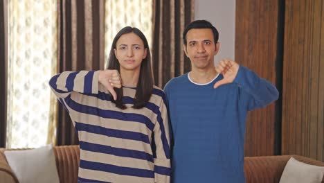 Disappointed-Indian-couple-showing-thumbs-down-to-the-camera