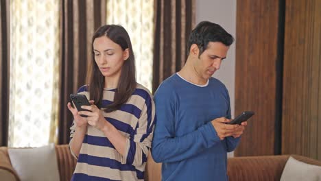 Indian-couple-using-phone-and-not-talking-to-each-other