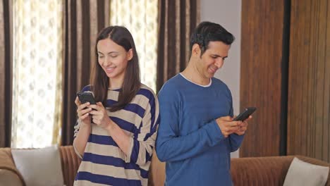 Glückliches-Indisches-Paar,-Das-Mobiltelefone-Benutzt