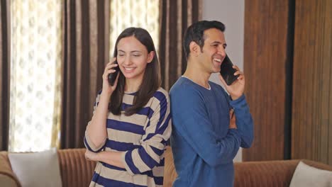 Glückliches-Indisches-Paar,-Das-Auf-Mobiltelefonen-Spricht